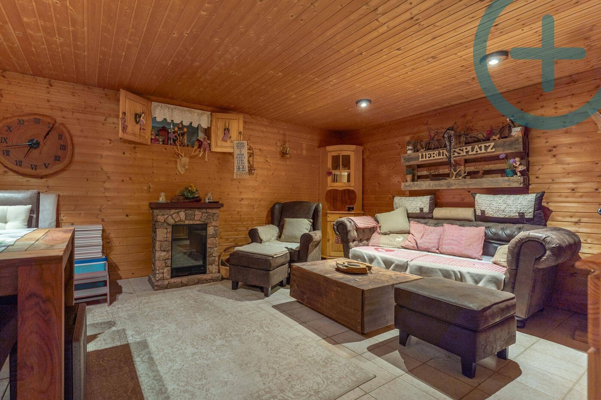 Gemütlicher Wohnbereich im Keller mit Holzverkleidung, Kamin und rustikalem Charme.
