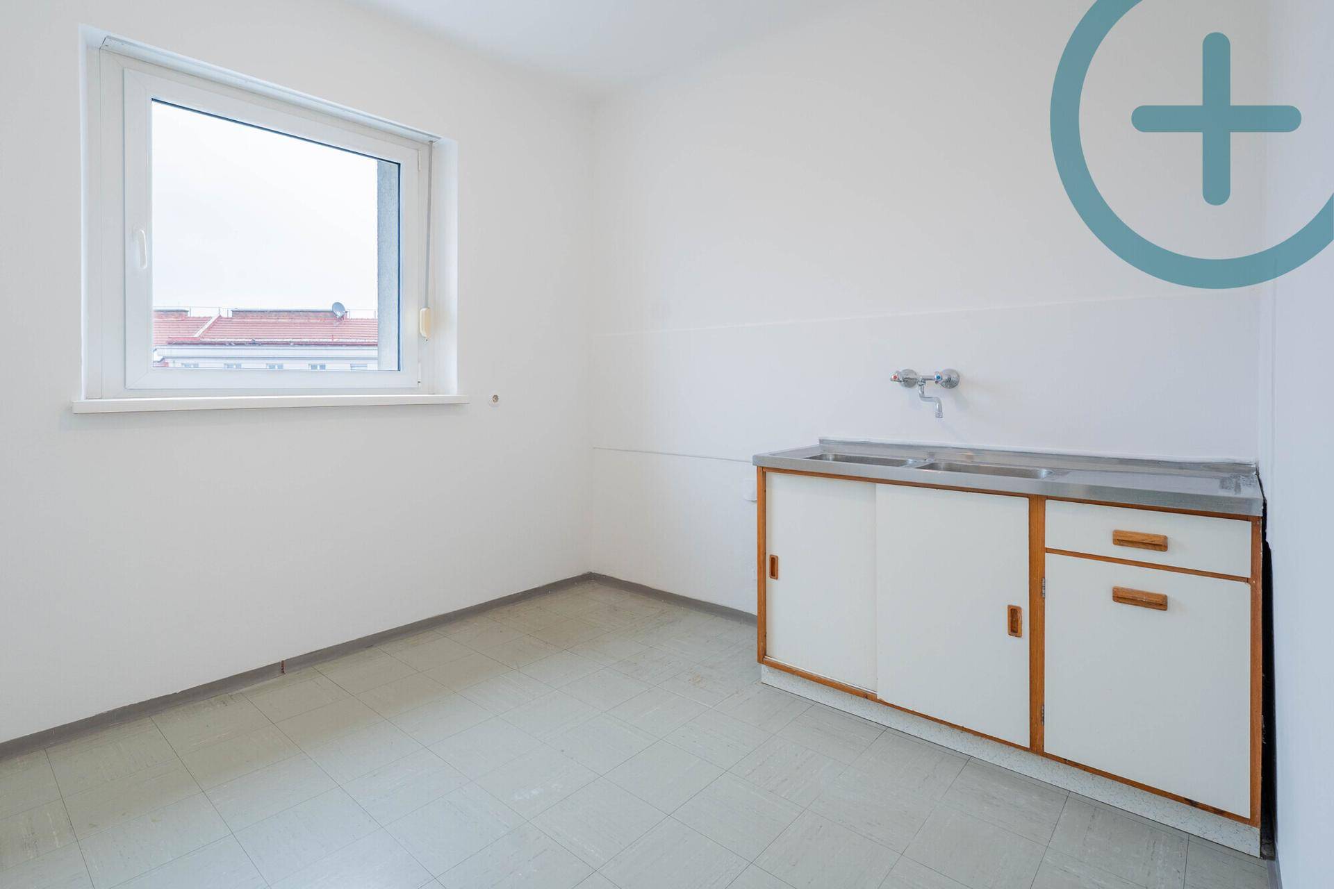 Funktionale Küche mit Spülbecken, Fenster und Fliesenboden, bereit zur individuellen Gestaltung.