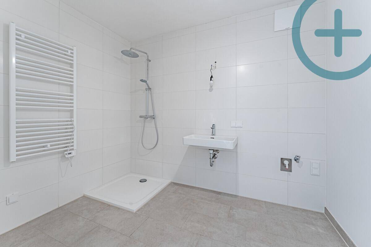 Modernes Badezimmer mit ebenerdiger Dusche, Waschbecken und beheiztem Handtuchhalter.