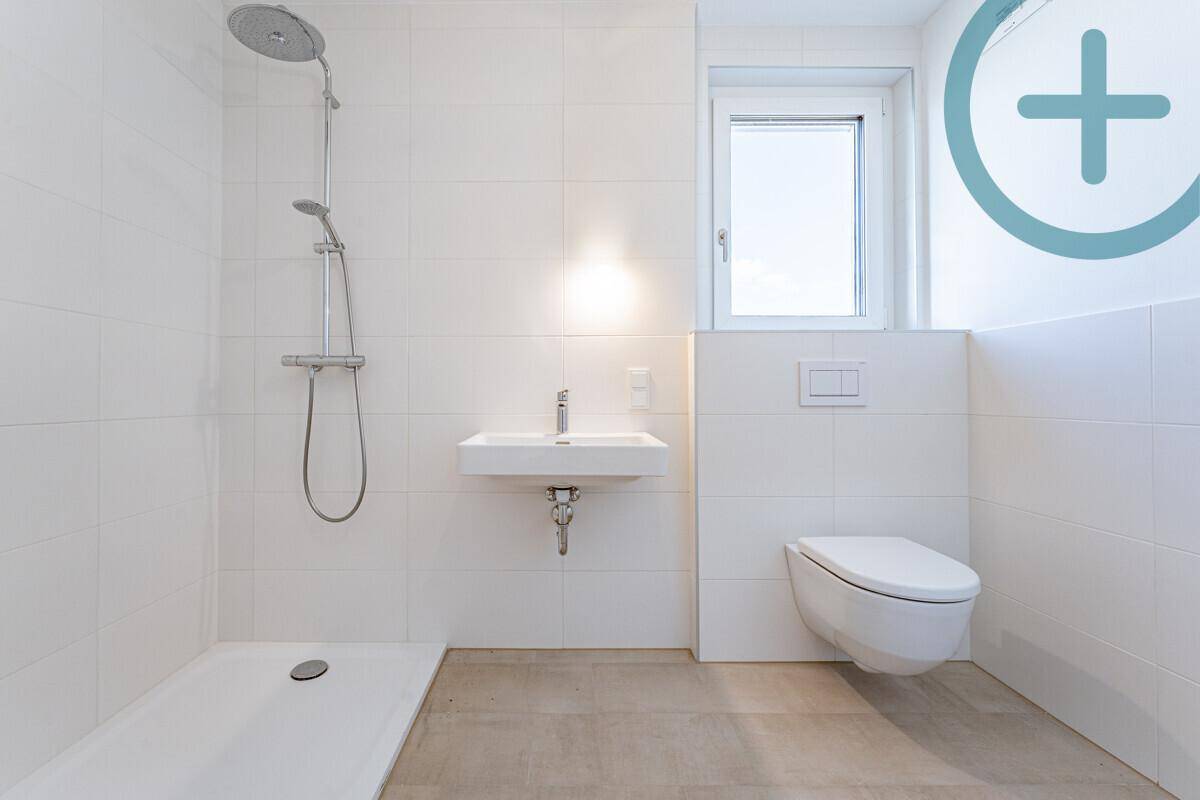 Modernes Badezimmer mit Dusche, Waschbecken, Toilette und Fenster für Tageslicht.