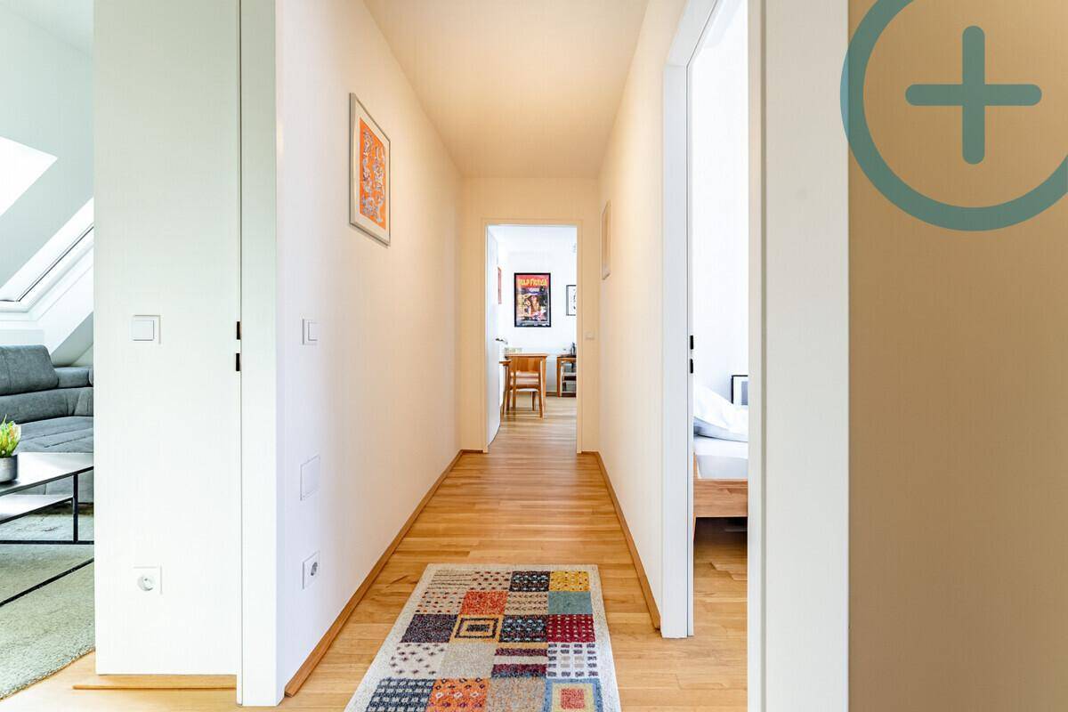 Heller Flur mit Holzboden, der zu den verschiedenen Räumen der Wohnung führt.