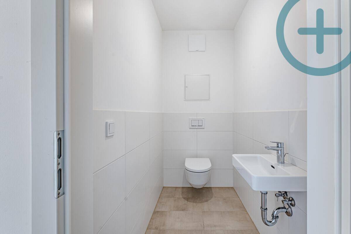 Modernes Gäste-WC mit wandhängender Toilette und kleinem Waschbecken.