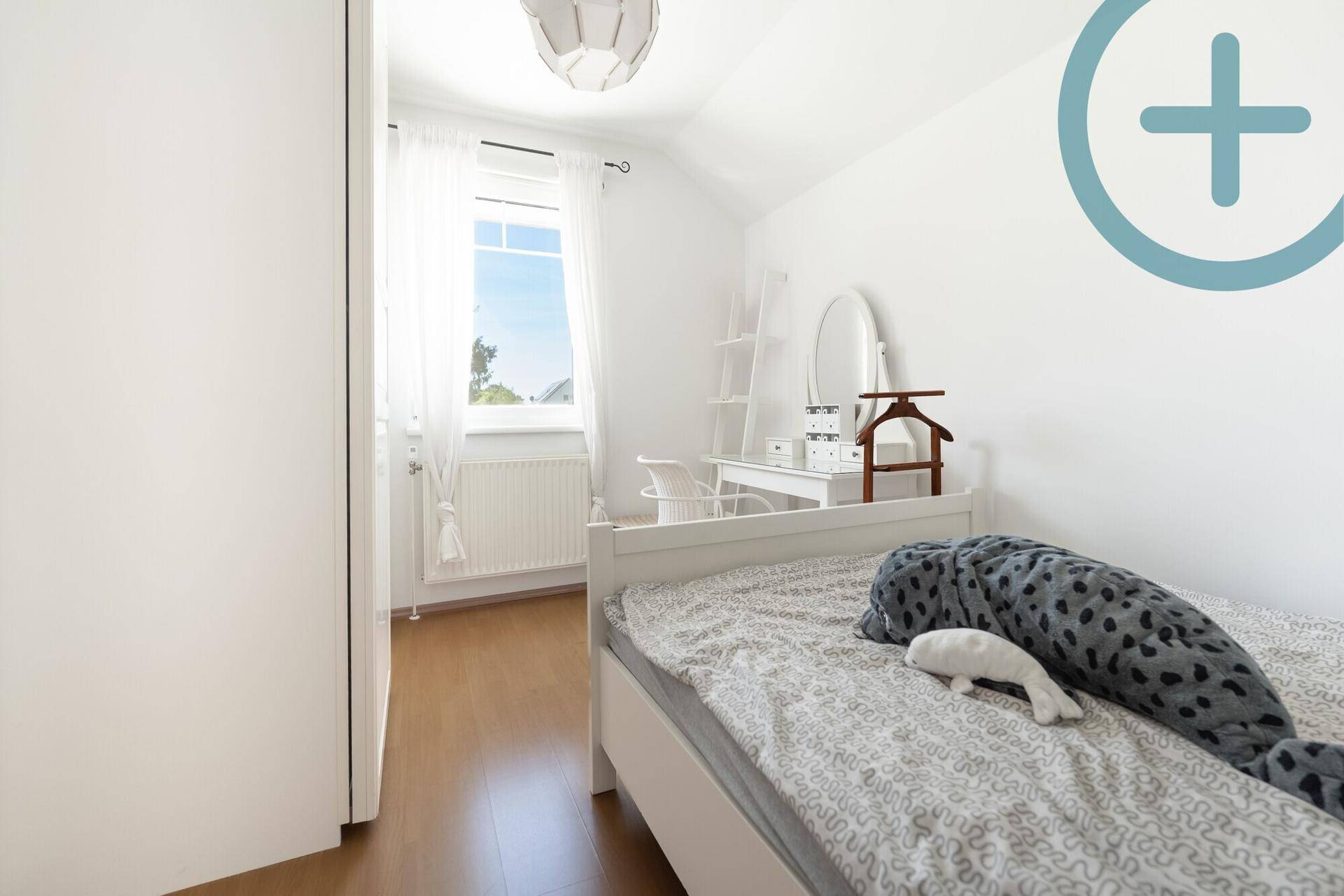 Kinderzimmer mit Einzelbett, weißen Möbeln und hellem Fenster für viel Tageslicht.