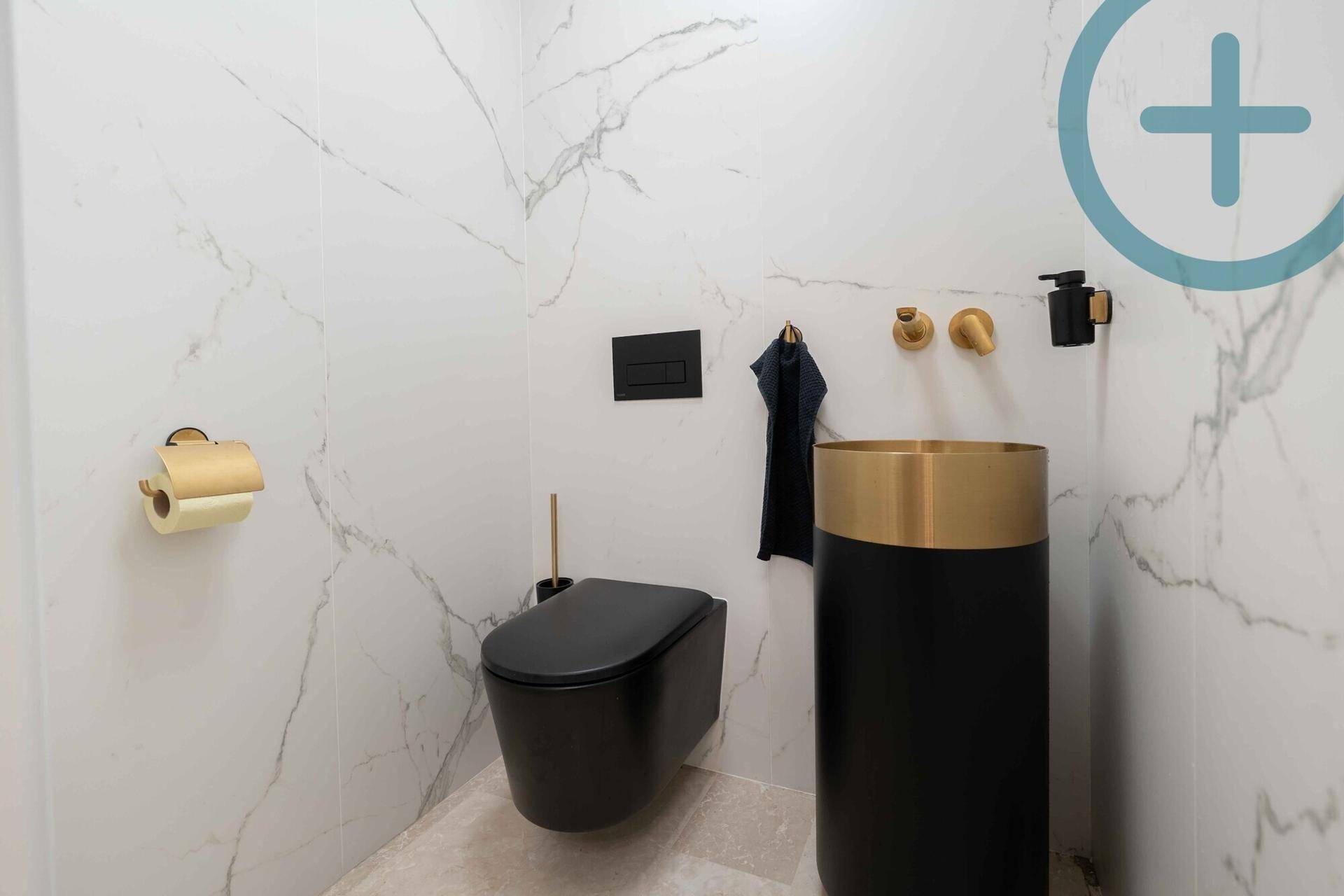 Modernes Gäste-WC mit Marmorfliesen, schwarzer Toilette und goldenen Armaturen.