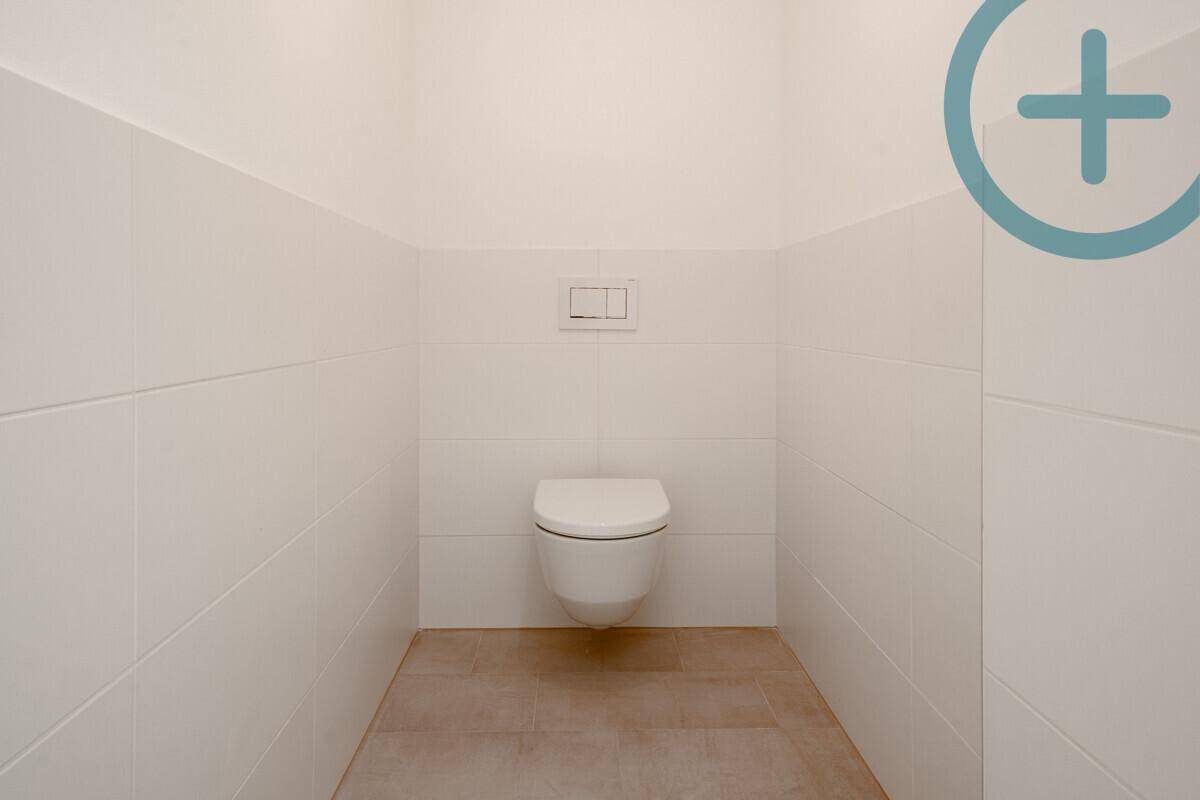 Separates Gäste-WC mit Hänge-WC und weißen Fliesen, in schlichtem, modernem Stil.