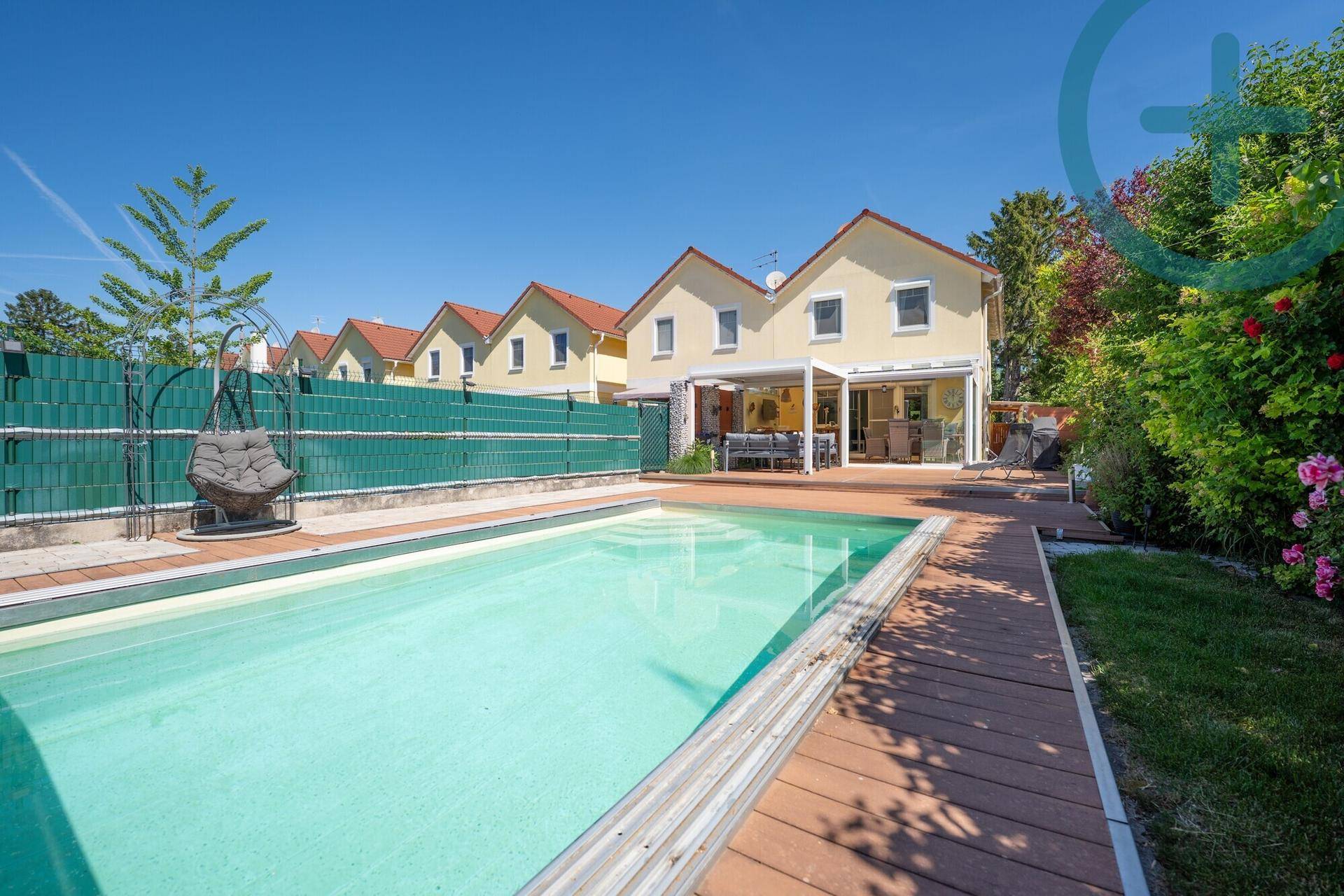 Sonniger Garten mit erfrischendem Pool und angrenzender Terrasse, ideal für Entspannung.