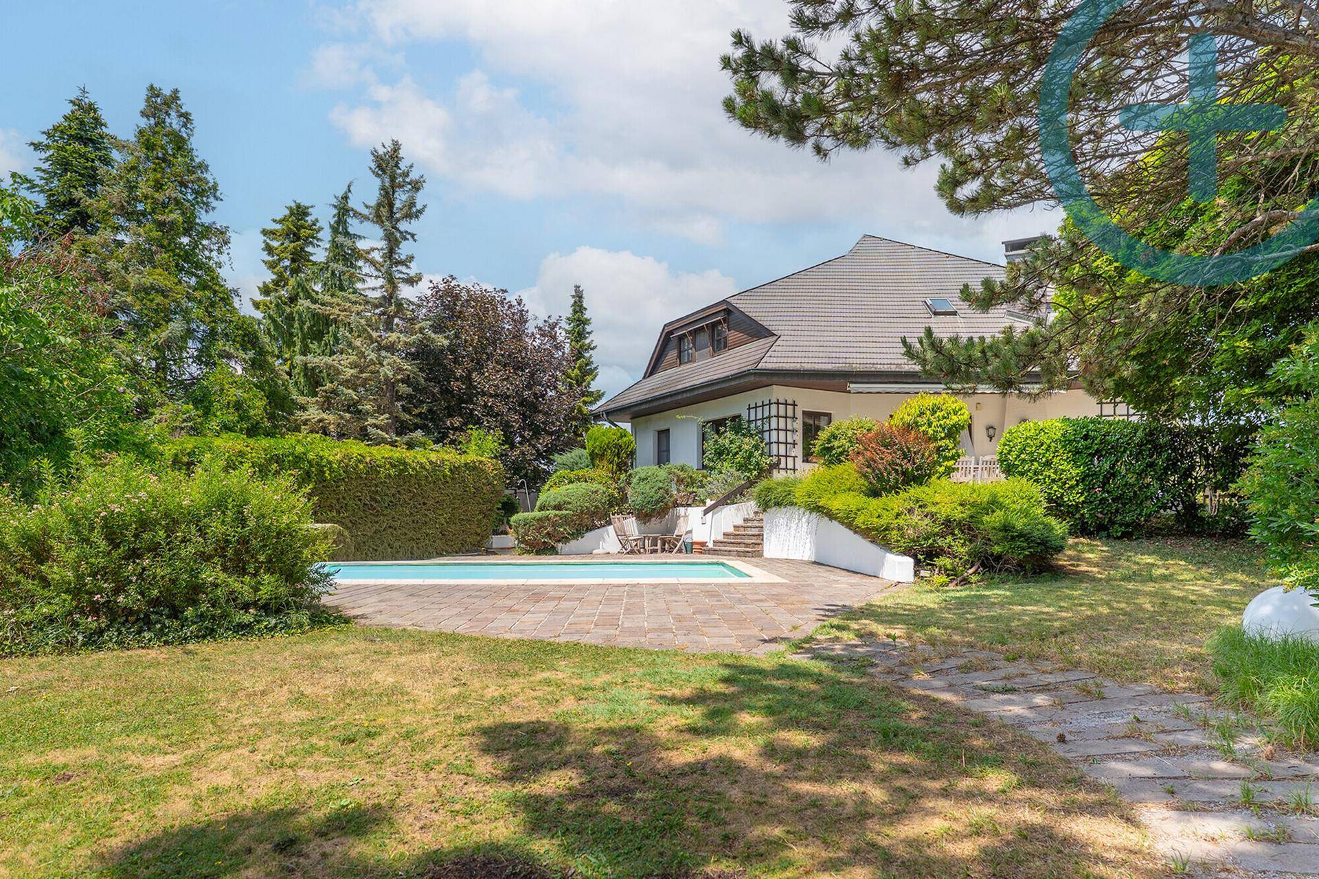 Weitläufiger Gartenbereich mit privatem Swimmingpool und sonniger Terrasse vor dem Wohnhaus.