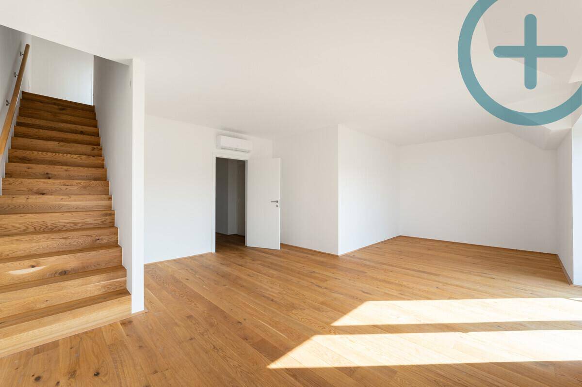 Geräumiger, heller Flur mit Holztreppe und Holzboden in einem modernen Neubau.