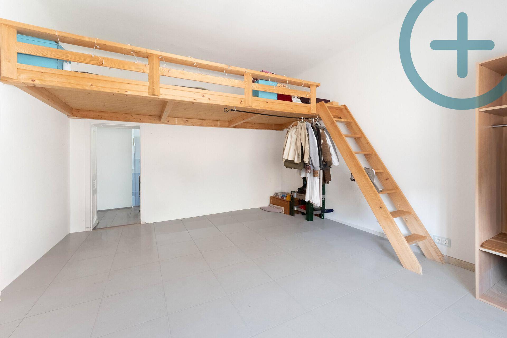 Schlafzimmer mit Hochbett aus Holz und viel freiem Raum, ideal für flexible Nutzung.