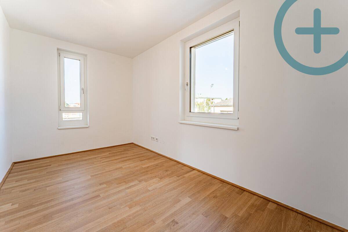 Geräumiges, helles Zimmer mit Parkettboden und zwei Fenstern für viel Tageslicht.