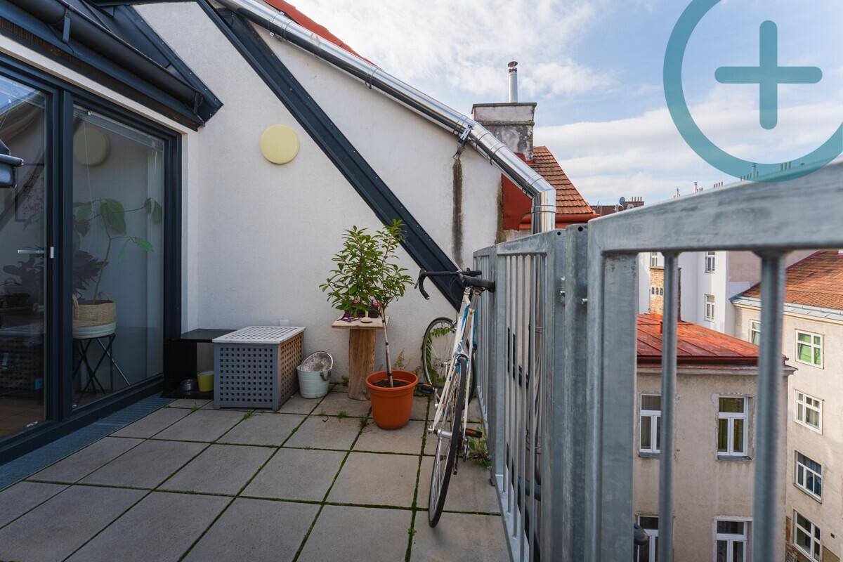 Sonniger Außenbereich auf der Dachterrasse mit Fahrradabstellplatz und Blick über die Dächer.