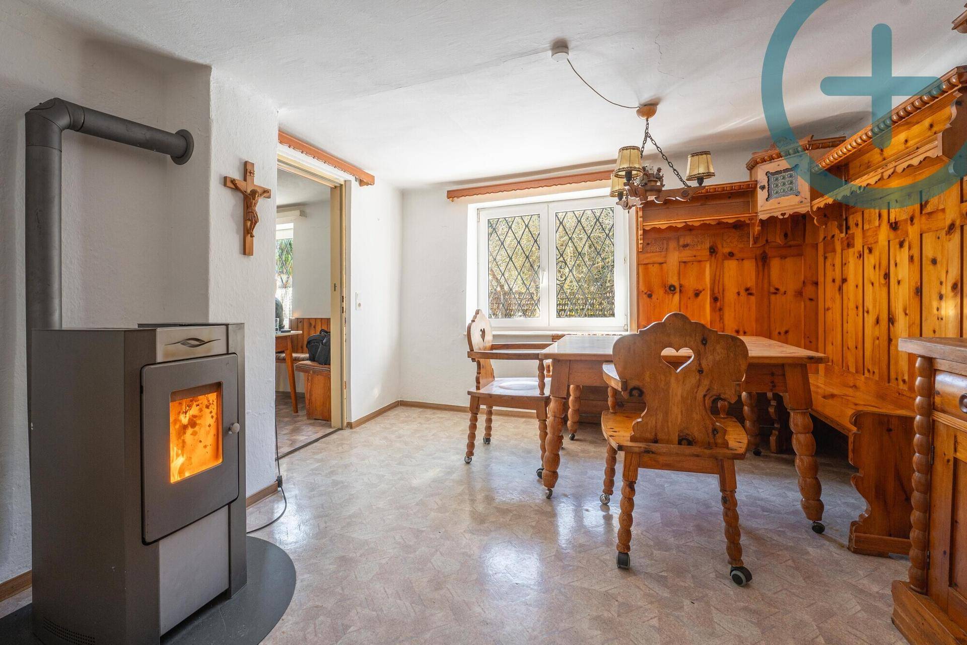 Rustikaler Essbereich mit traditionellen Holzmöbeln und einem modernen Kaminofen.