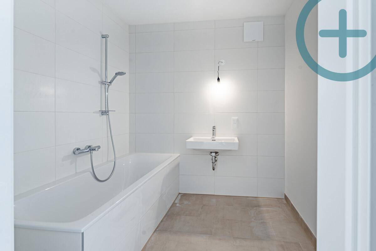 Modernes Badezimmer mit Badewanne, Duscharmatur und Waschbecken.