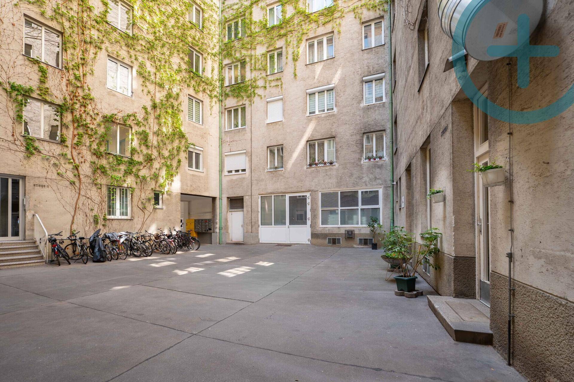 Innenhof eines Wohngebäudes mit Fahrradabstellplätzen und begrünten Fassaden.