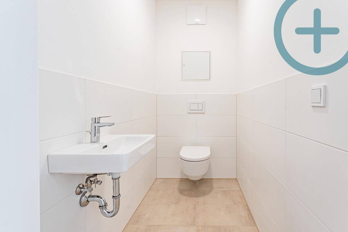 Modernes Gäste-WC mit wandhängender Toilette und kleinem Waschbecken.