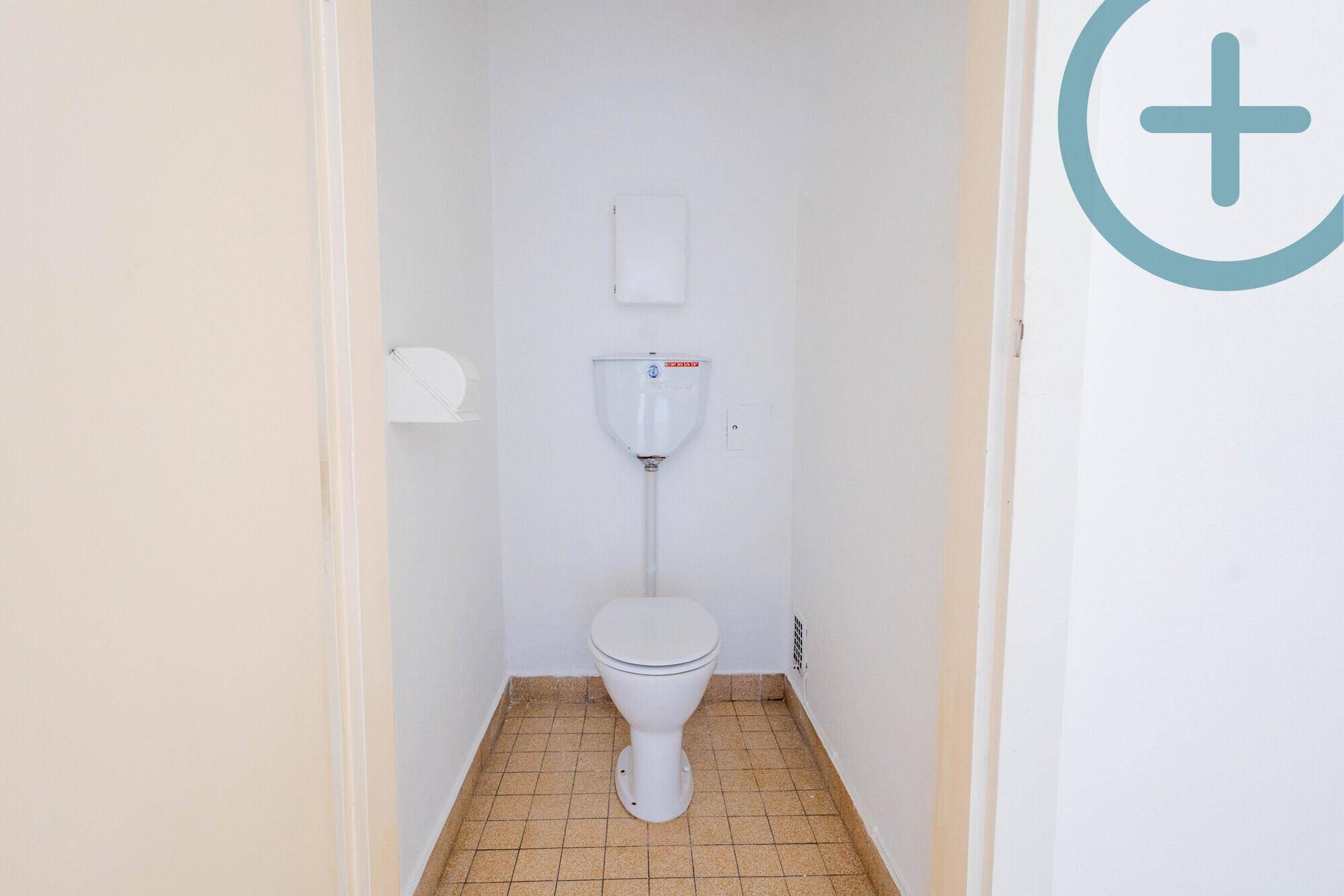 Separates WC mit Steh-WC und gefliestem Boden.
