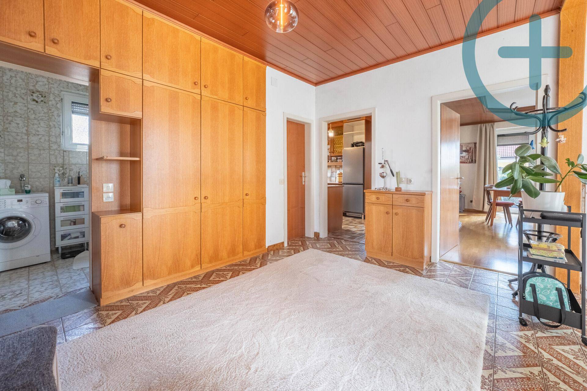 Geräumiger Flur mit Holzdecke, Fliesenboden und großem Einbauschrank.