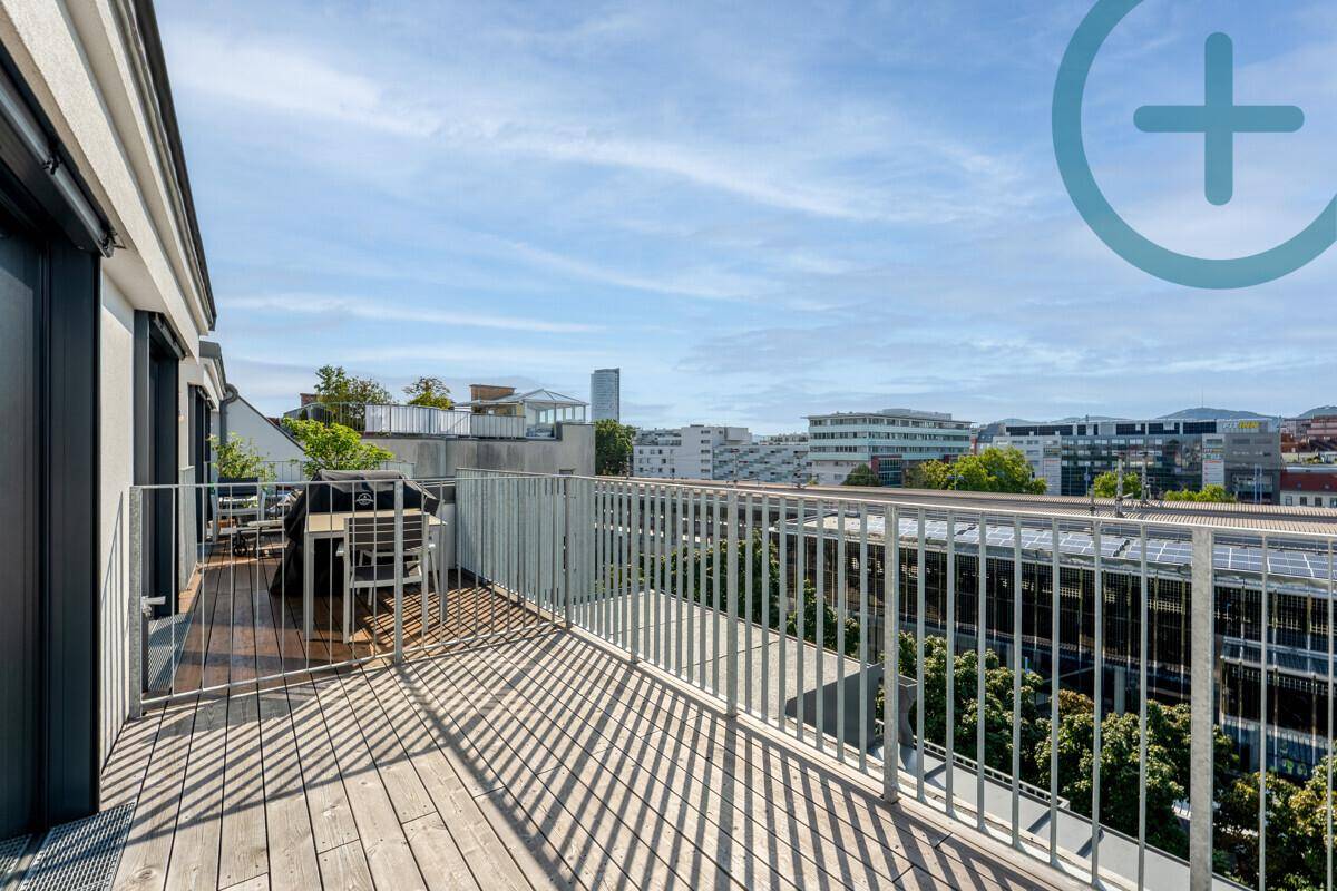 Großer Balkon mit Holzboden, Sitzgelegenheiten und Panoramablick auf die städtische Umgebung.