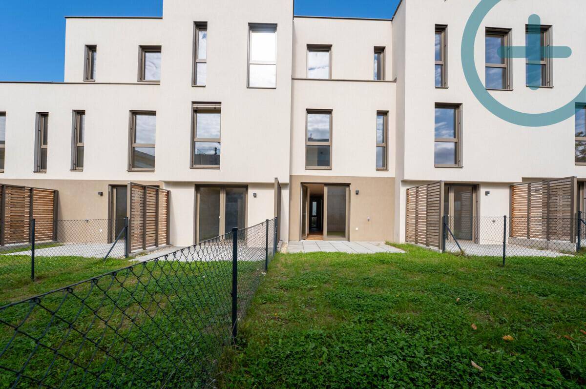 Rückseite der modernen Reihenhäuser mit privaten Terrassen und Gärten, ideal für Entspannung.