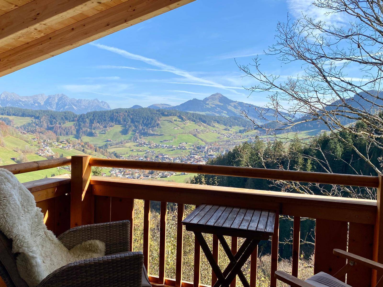 Gemütlicher Balkon mit Sitzgelegenheiten und atemberaubendem Panoramablick auf die Berge und das Tal.