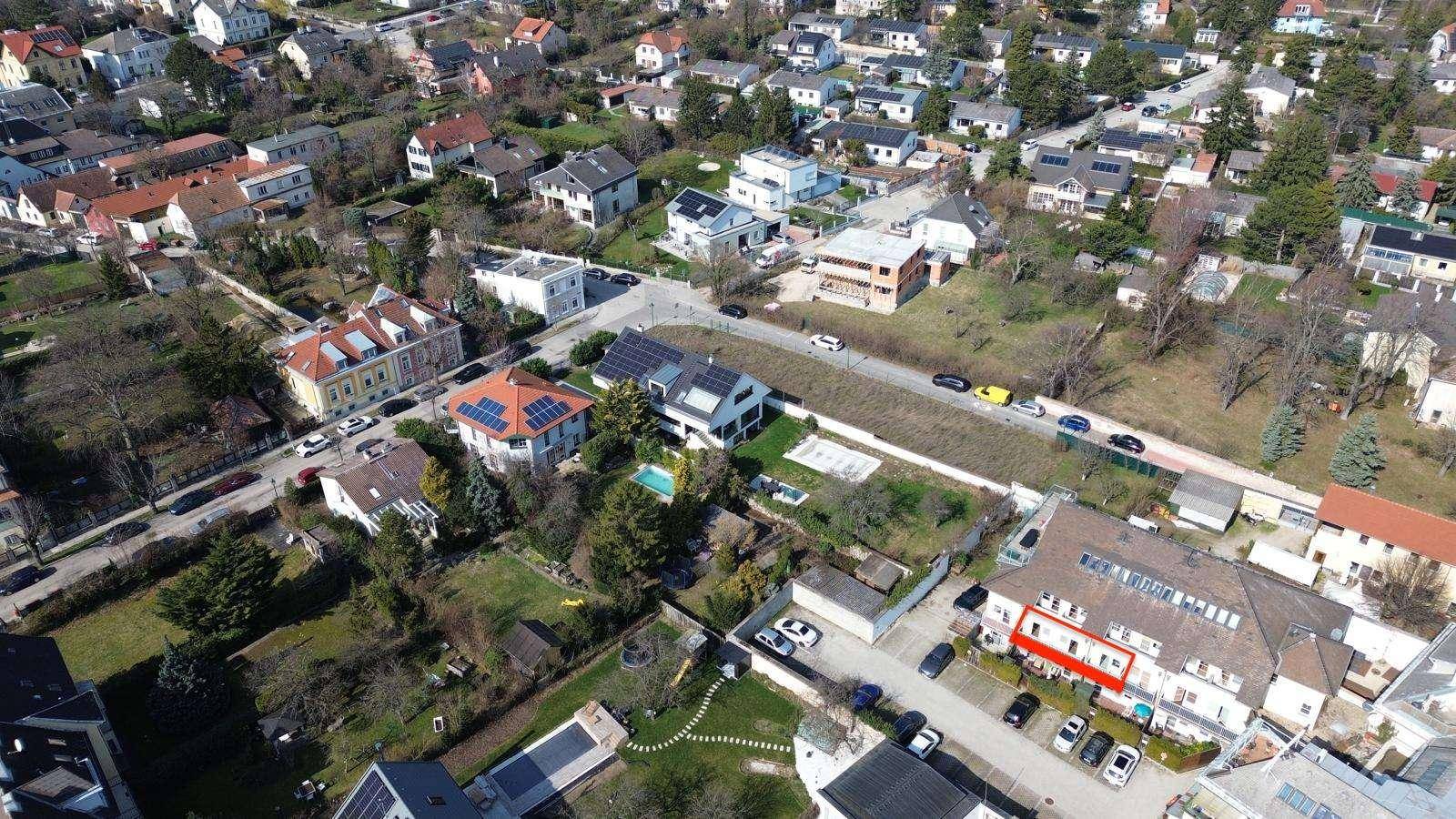 Luftaufnahme der Wohngegend mit hervorgehobenem Gebäude und umliegenden Häusern.