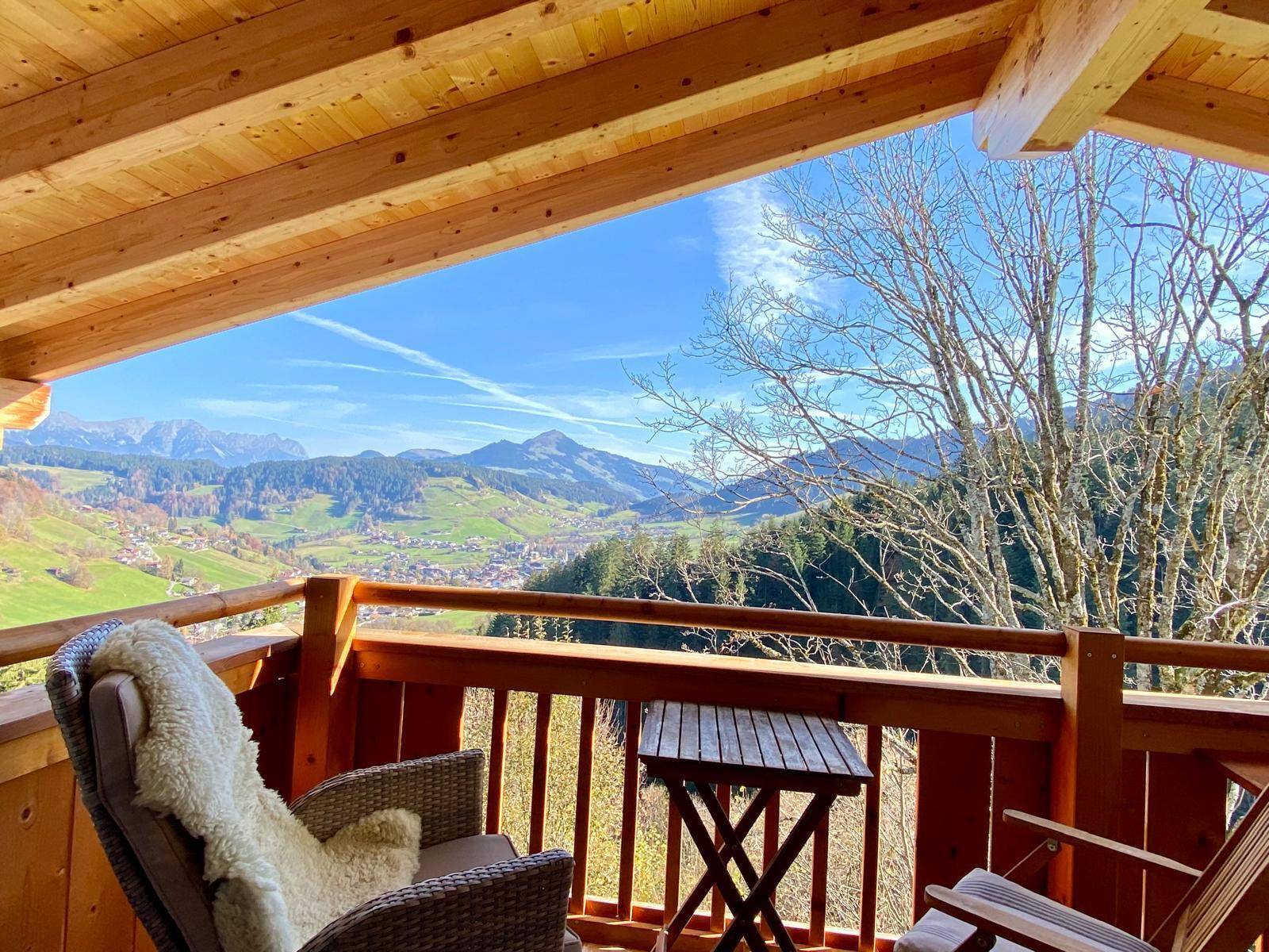 Gemütlicher Balkon mit Sitzgelegenheiten und atemberaubendem Panoramablick auf die Berge und das Tal.