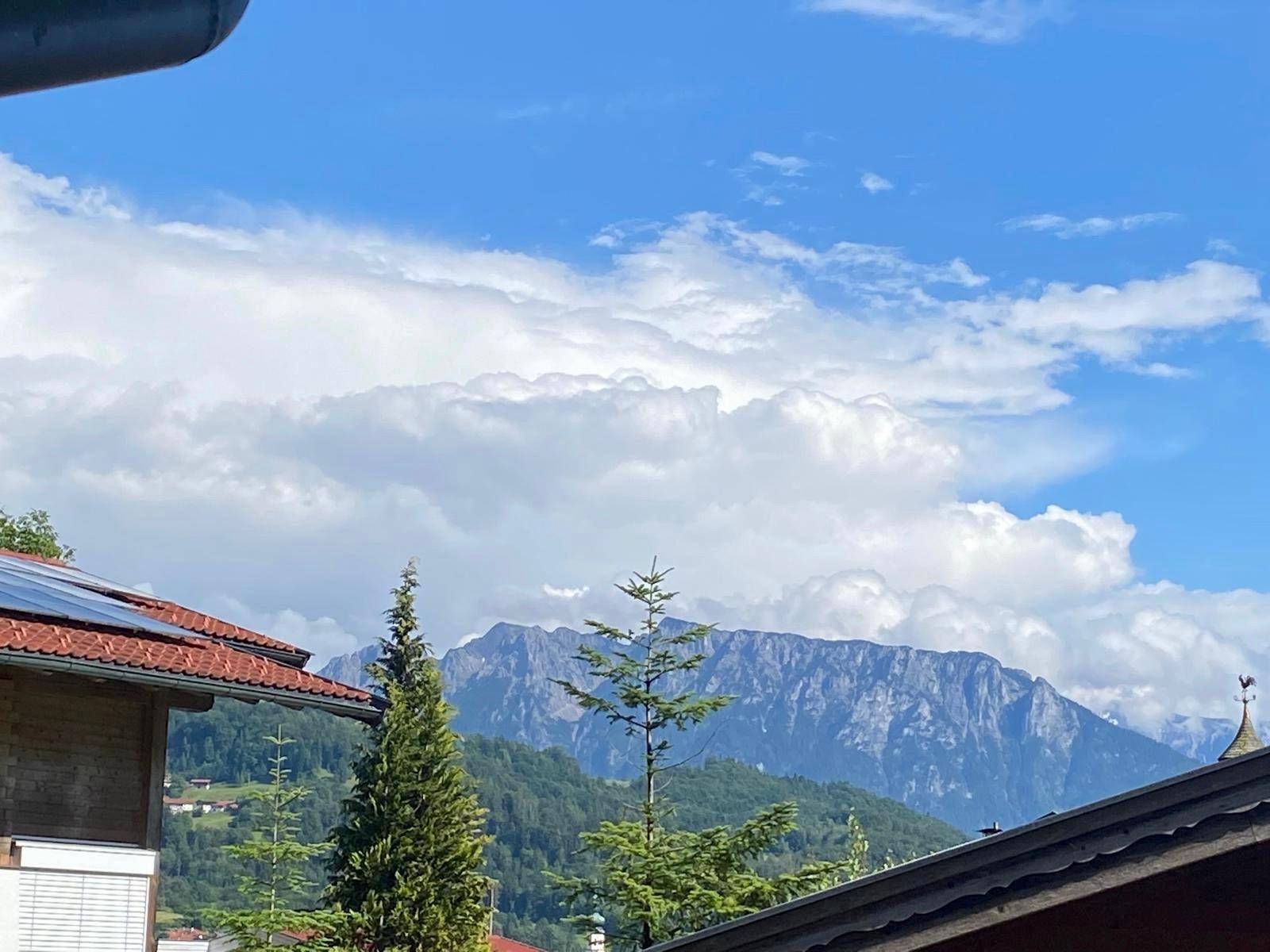 Panoramablick auf die majestätischen Berge unter einem strahlend blauen Himmel mit Wolken.