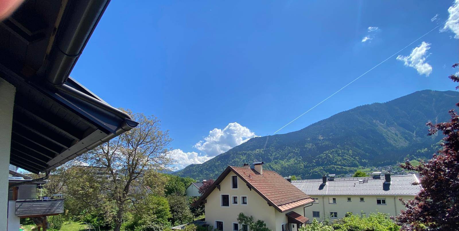 Weitläufiger Bergblick über die Dächer der Häuser an einem klaren Sommertag.