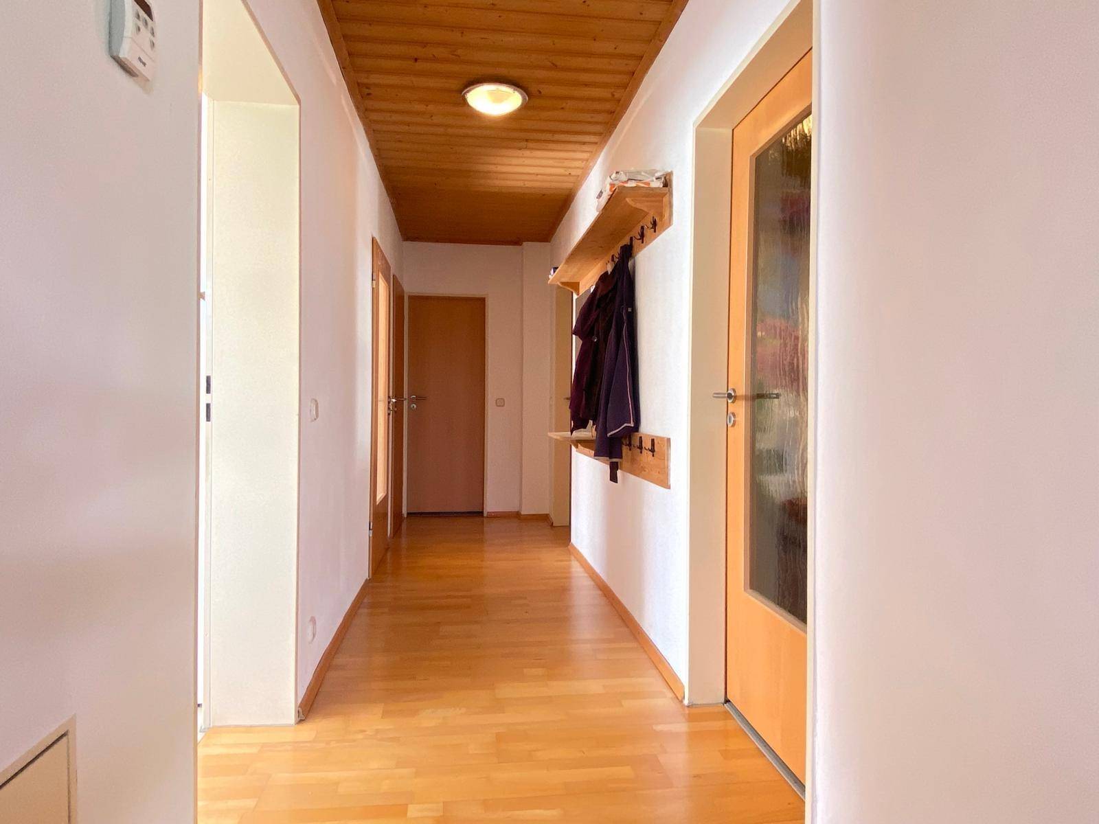 Heller Flur mit Holzdecke und Laminatboden, ausgestattet mit einer Garderobe.