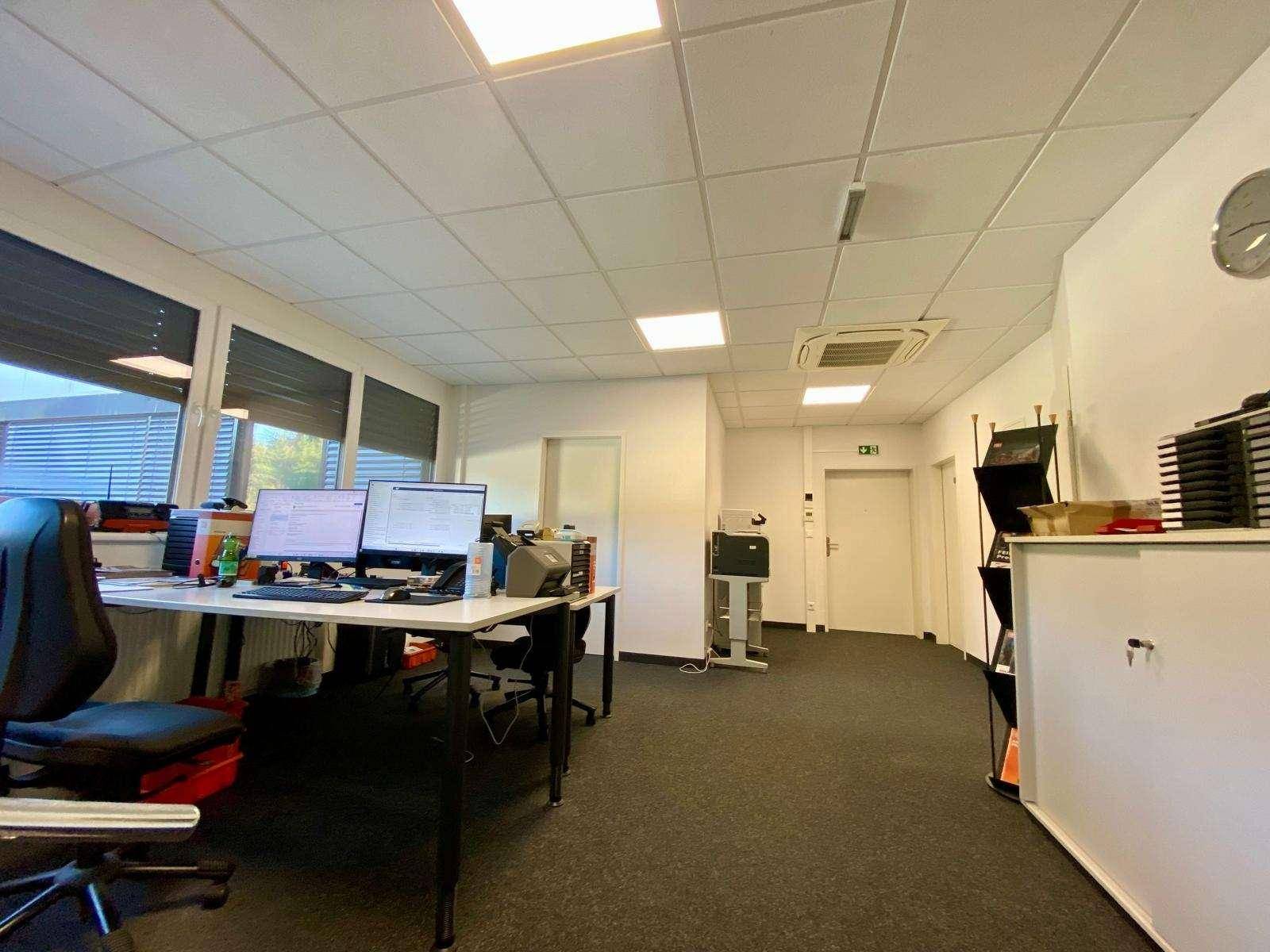 Großes Open-Space-Büro mit mehreren Arbeitsplätzen, Computern und Klimaanlage für ein komfortables Arbeitsklima.