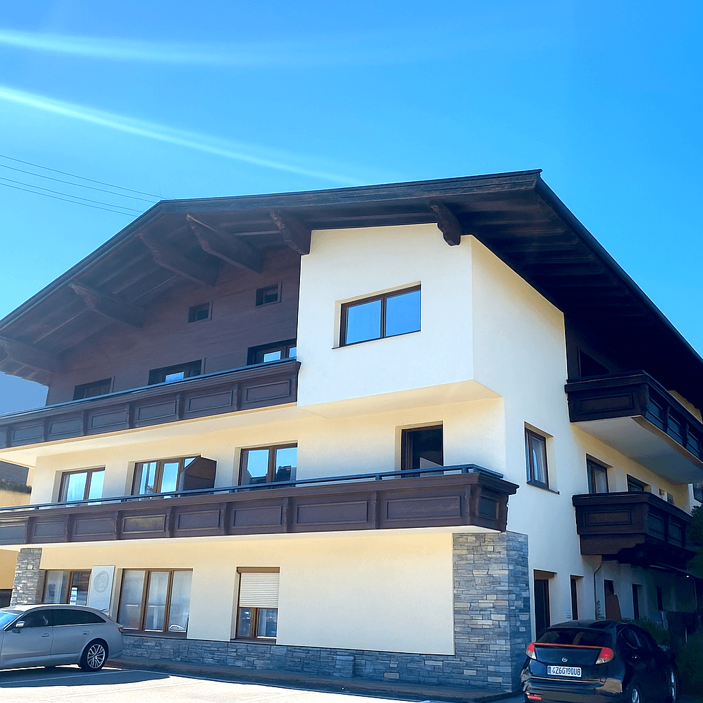 Attraktive Fassade eines modernen Gebäudes mit traditionellen Holzelementen und großen Fenstern.