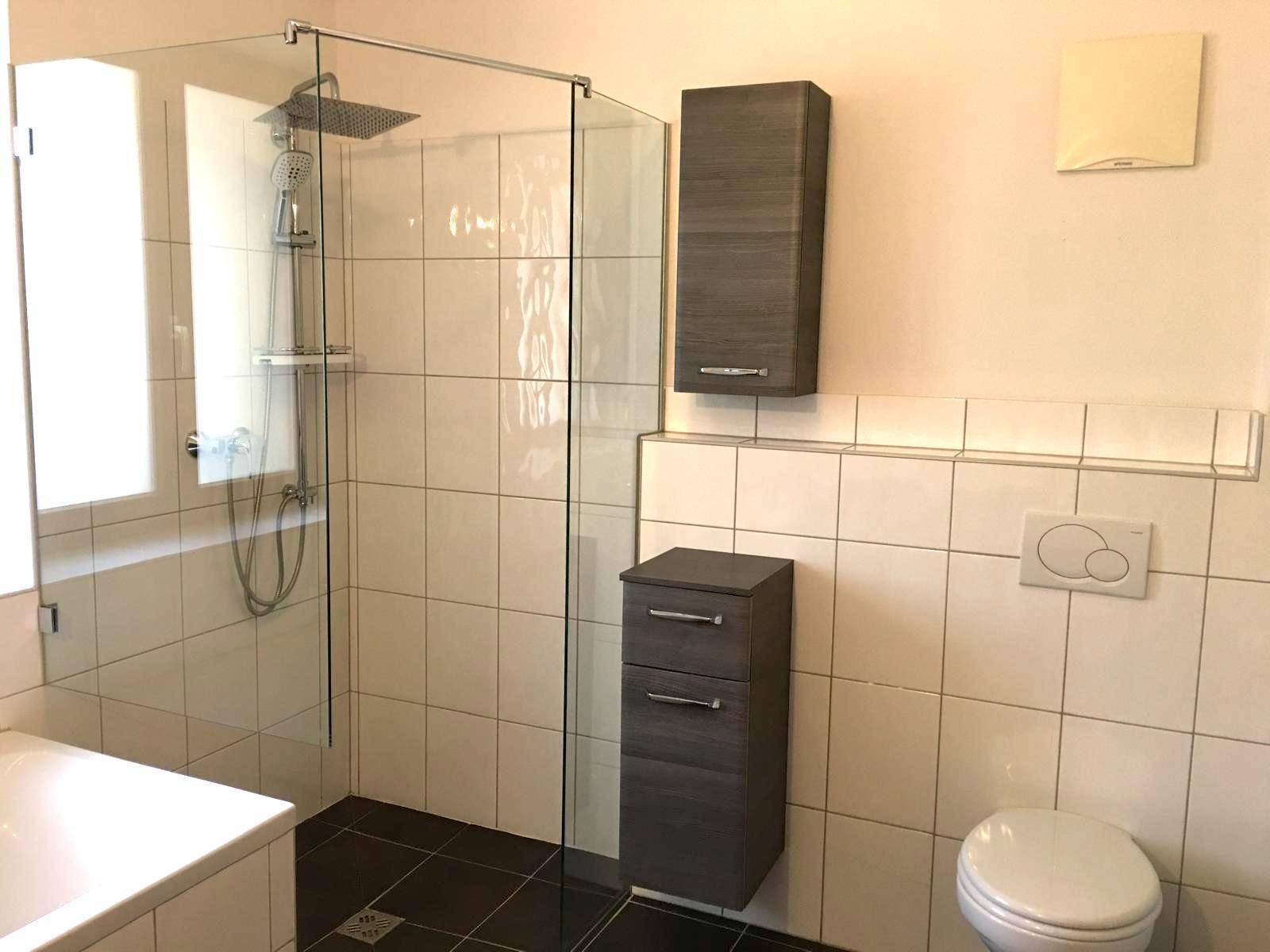 Modernes Badezimmer mit ebenerdiger Dusche, Badewanne und Wand-WC.