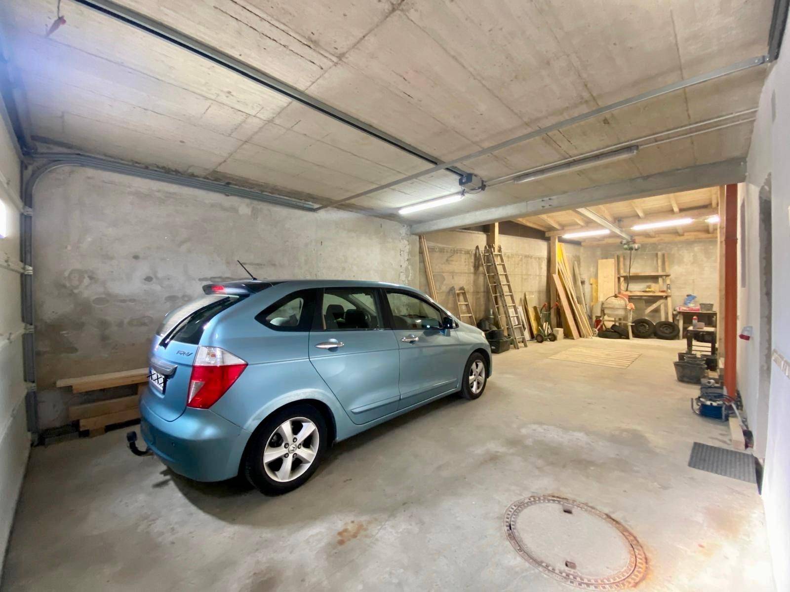 Geräumige Garage mit Betonboden und ausreichend Platz für ein Fahrzeug und Lagerung.