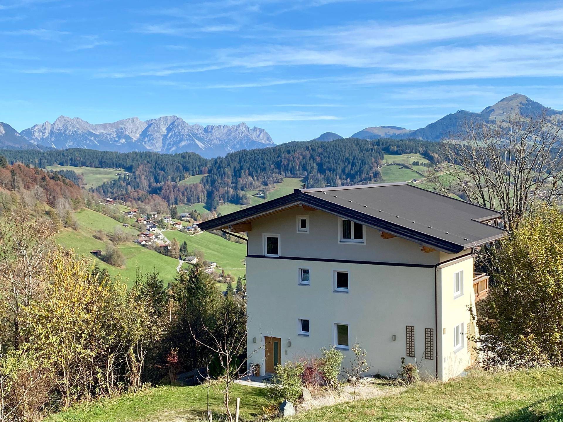 Das Haus in sonniger Hanglage mit Blick auf die umliegende Bergwelt und das Tal.