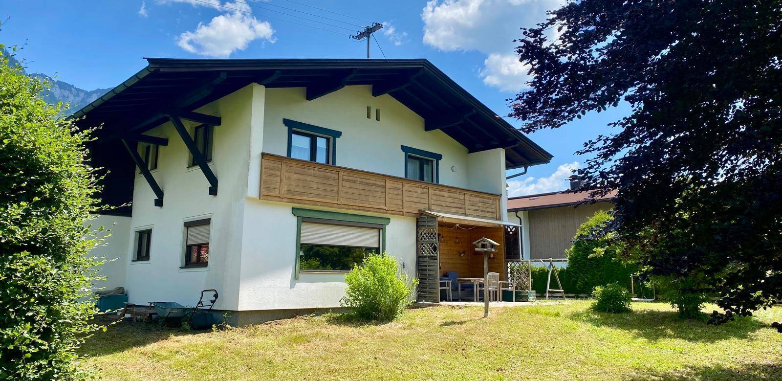 Charmantes Haus mit überdachter Terrasse und Garten in ländlicher Umgebung.