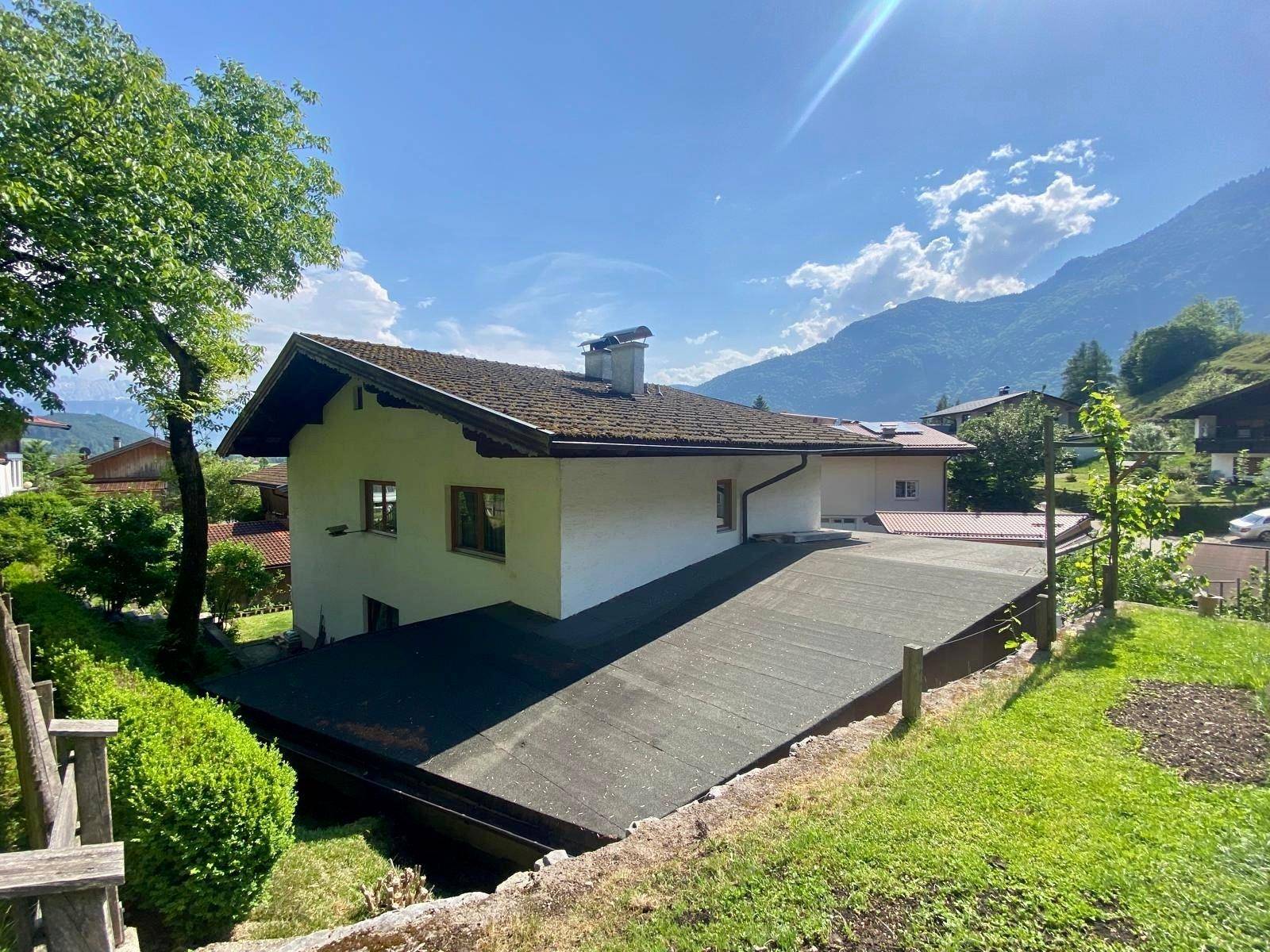 Rückseite des Hauses mit Satteldach und Blick auf die umliegende Berglandschaft.