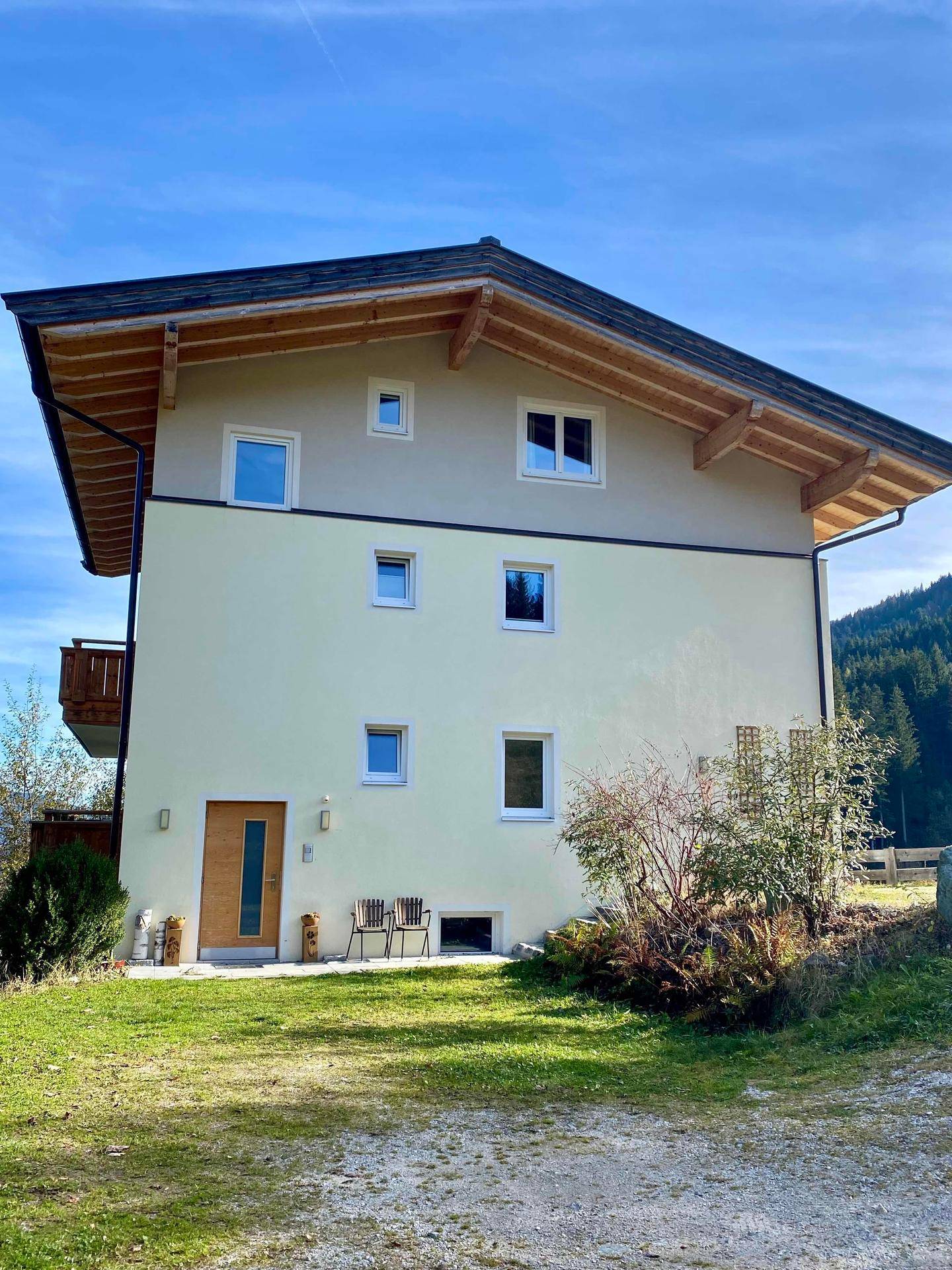 Vorderansicht des Hauses mit gepflegtem Vorgarten und traditionellem Holzeingang.