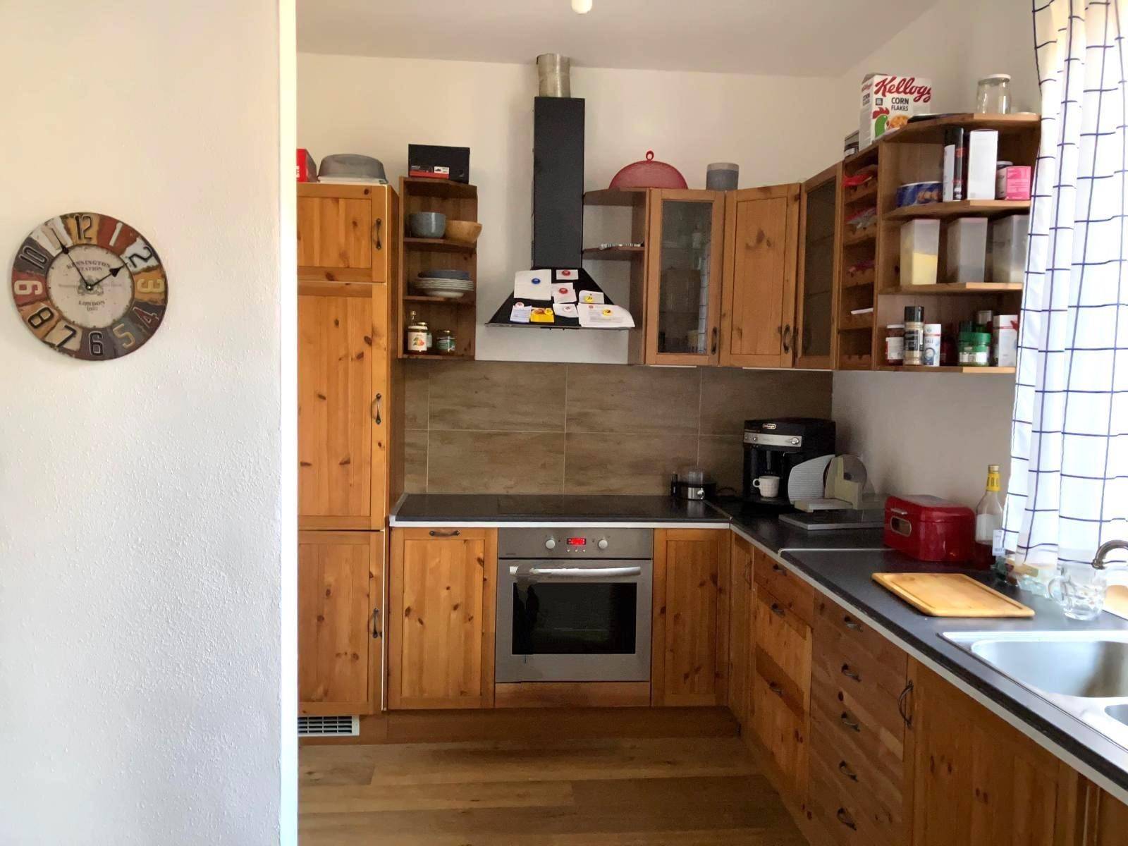 Rustikale Holzküche mit Einbauschränken, dunkler Arbeitsplatte und integriertem Backofen.