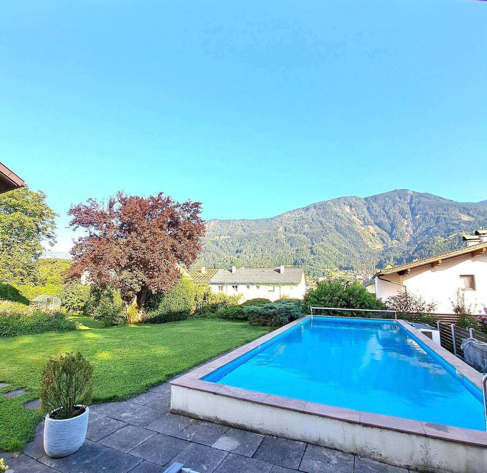 Außenbereich mit Swimmingpool, Terrasse und weitem Blick auf die Berge.