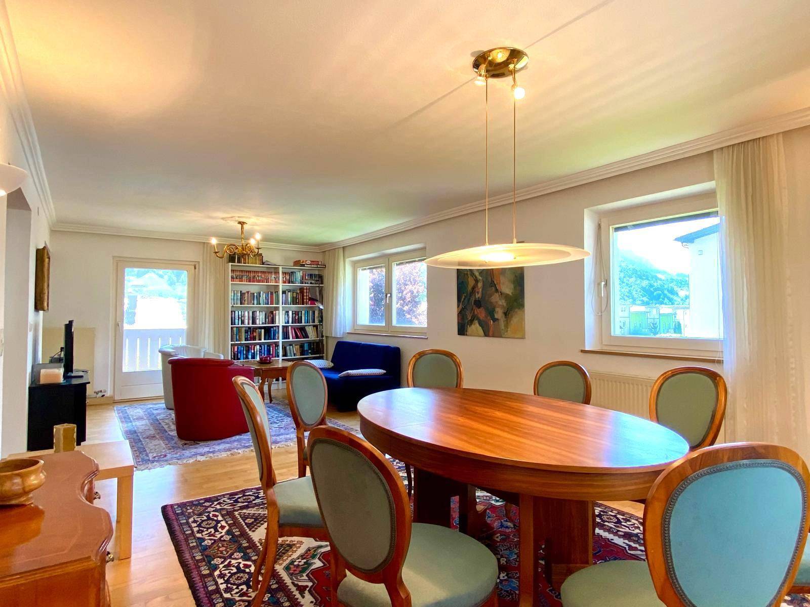 Heller Wohn-Essbereich mit elegantem Esstisch, Bücherregal und Zugang zum Balkon.