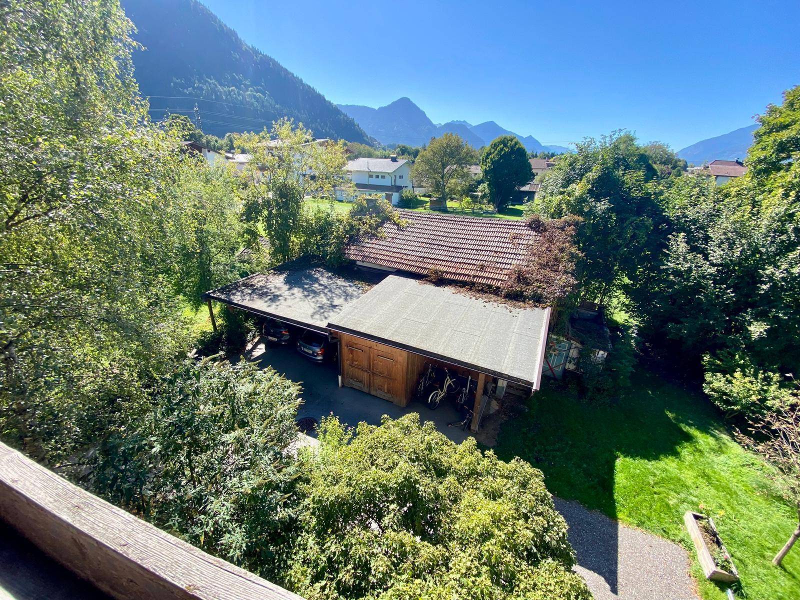 Blick von oben auf den Gartenbereich mit Carport und angrenzendem Gebäude.