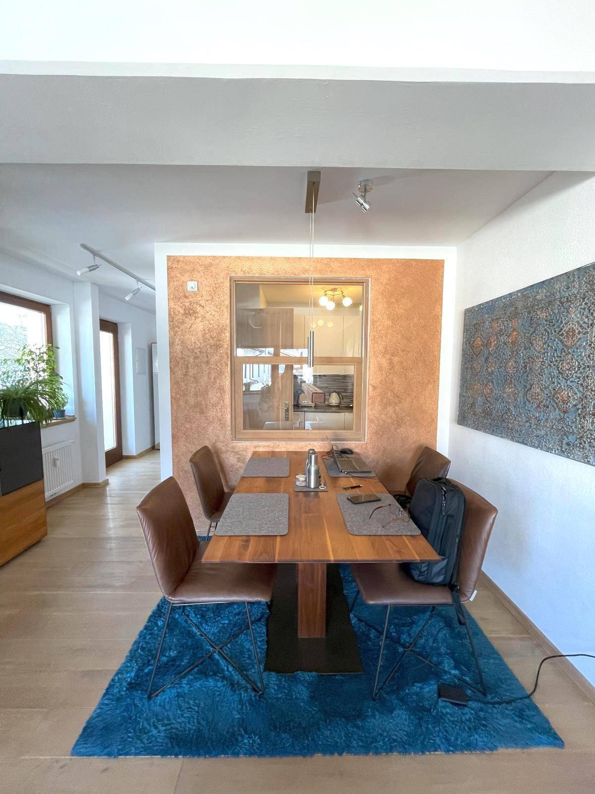 Heller Essbereich mit Holztisch, modernen Stühlen und Blick in die angrenzende Küche.
