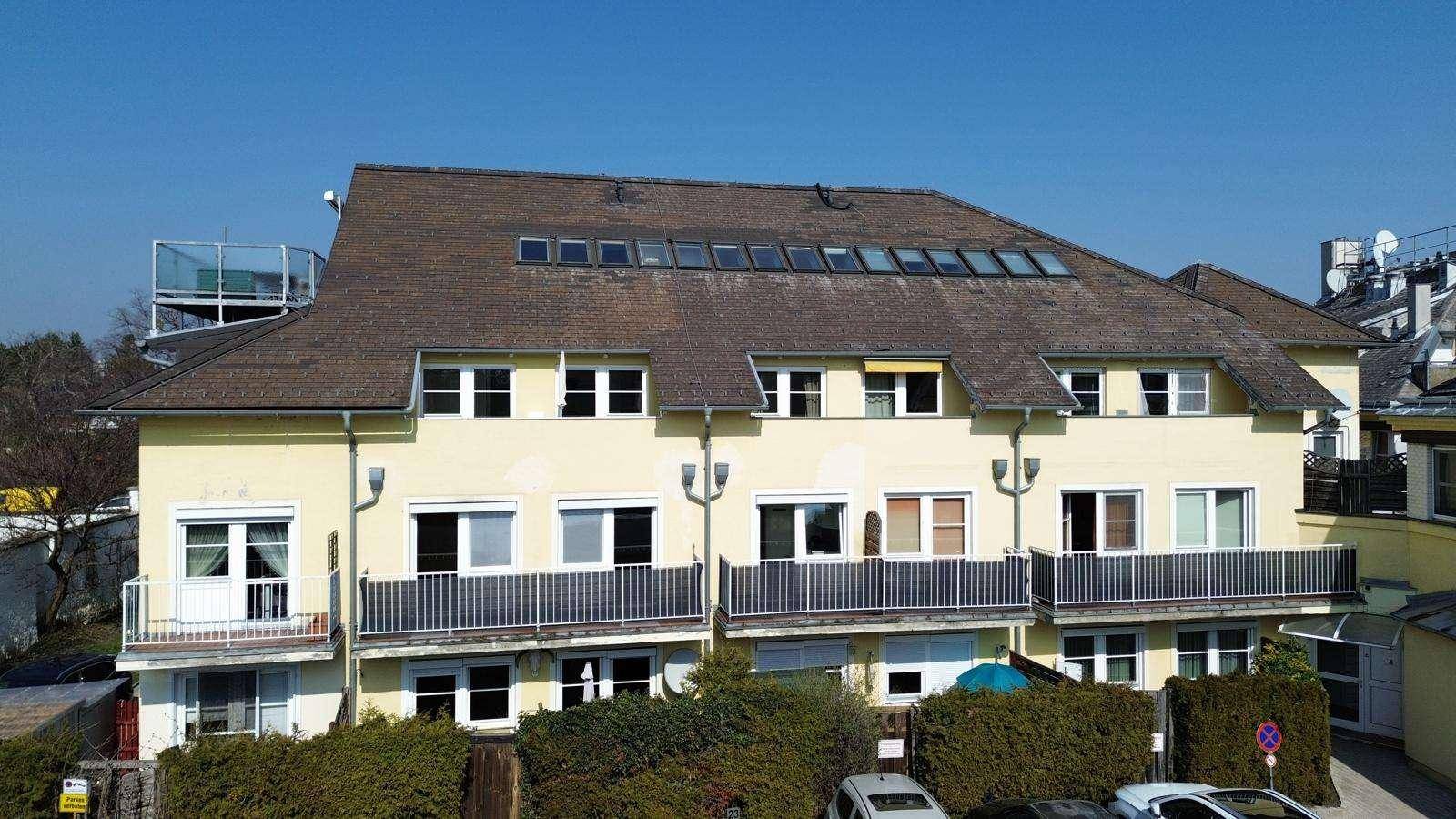 Ansicht der Gebäudefassade mit mehreren Balkonen und Dachfenstern.