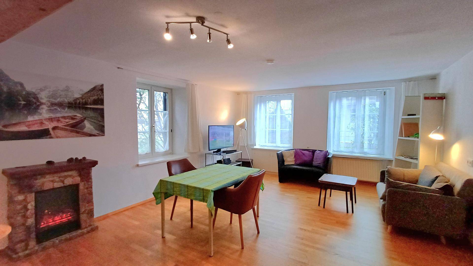 Geräumiger Wohn-Essbereich mit Kamin, Esstisch und bequemen Sitzgelegenheiten.