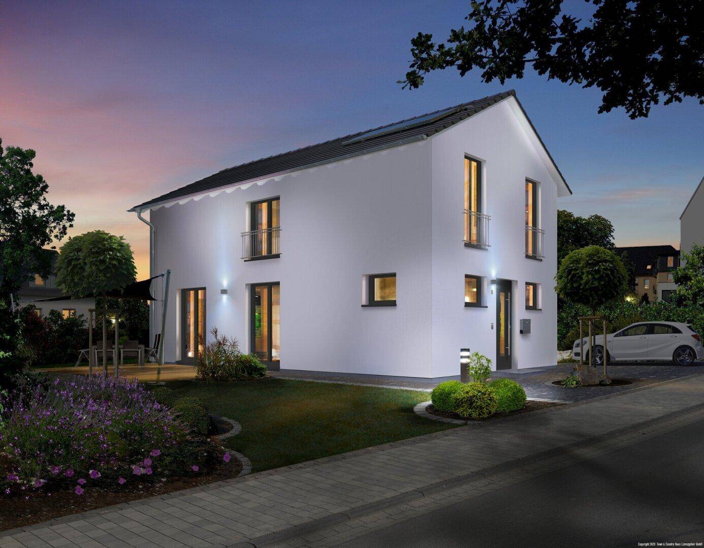 Modernes Einfamilienhaus bei Abenddämmerung mit beleuchteter Fassade und Vorgarten.