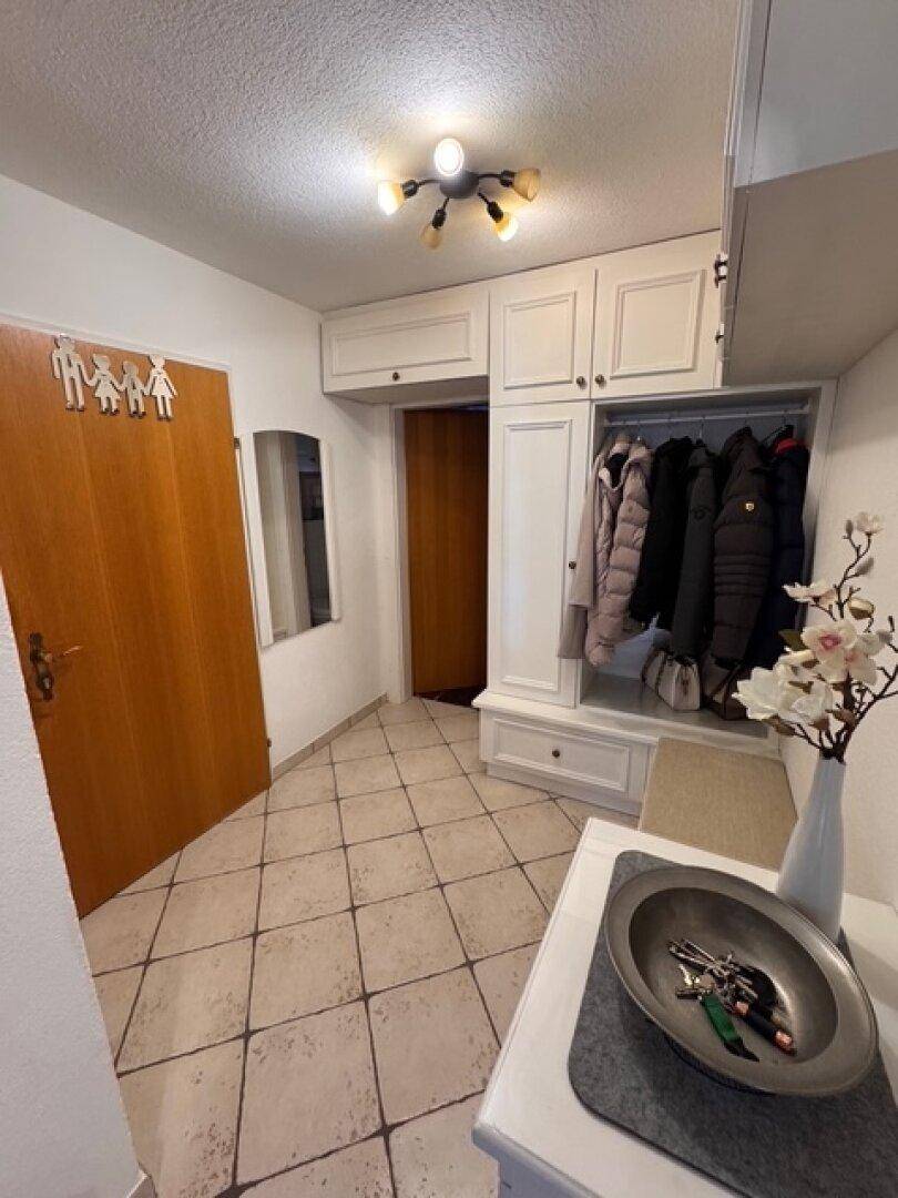 Eingangsbereich mit praktischem Einbauschrank, Fliesenboden und Garderobe.