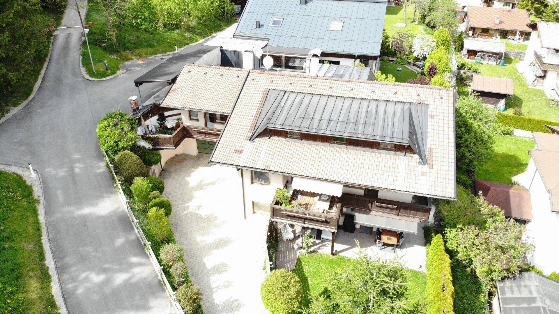 Dachansicht des Hauses mit Solarpaneelen, Balkonen und einem weitläufigen Gartenbereich.