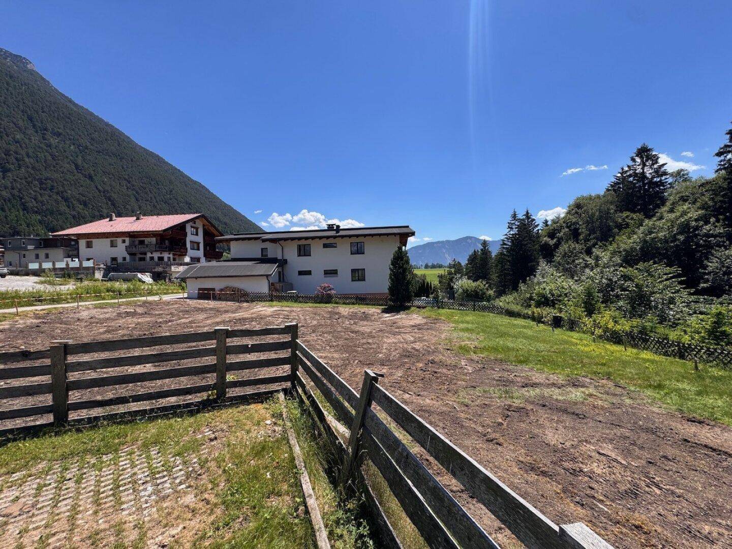 Freies Baugrundstück in alpiner Umgebung mit Blick auf die Berge und umliegende Natur.