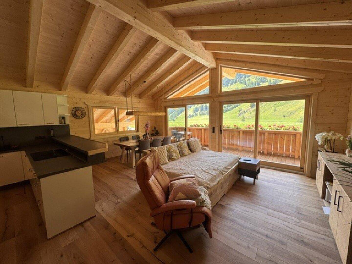 Offener Wohn- und Essbereich mit Holzboden, hohen Decken und Panoramablick.