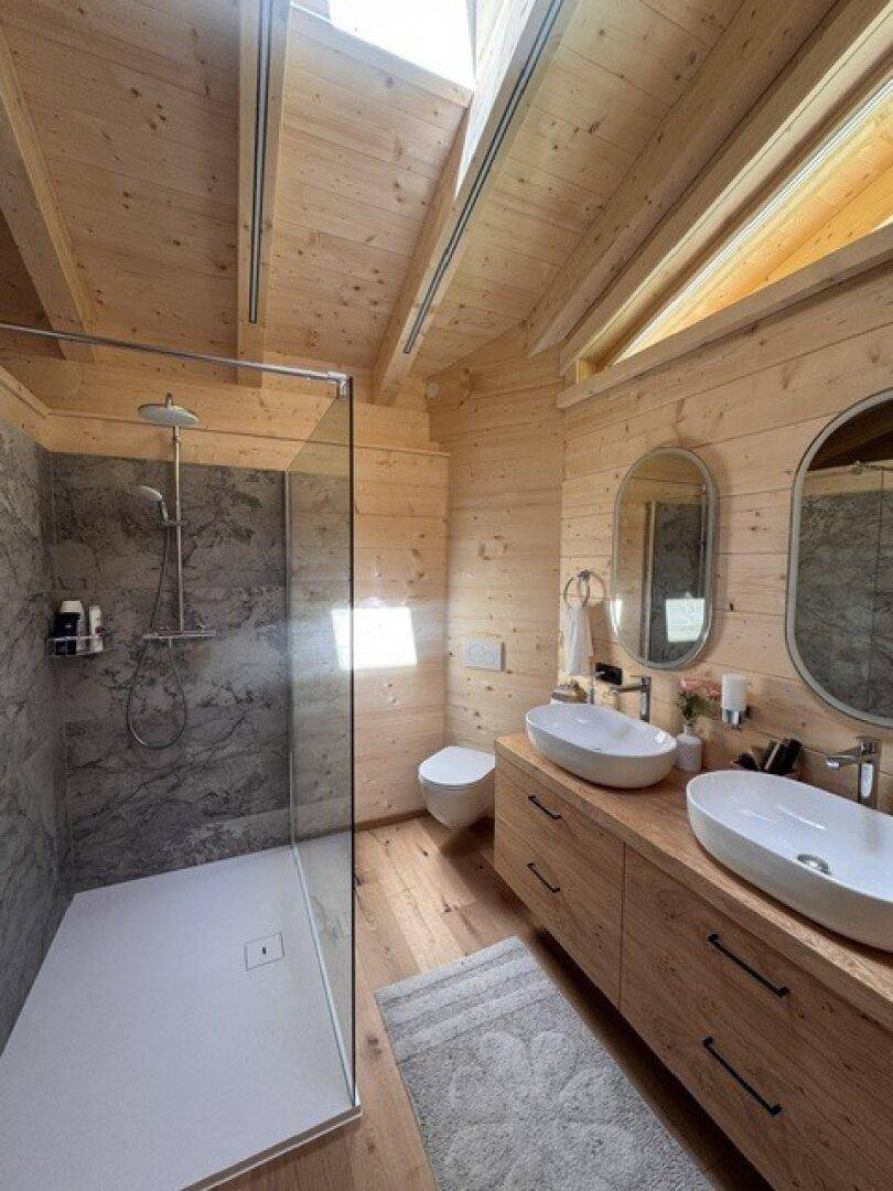 Stilvolles Badezimmer mit begehbarer Dusche, Doppelwaschbecken und Dachfenster.
